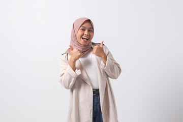 Portrait of attractive Asian hijab woman in casual suit making thumb up hand gesture, saying good...