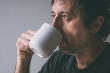  Unkempt man drinking morning coffee from a white mug © Bits and Splits