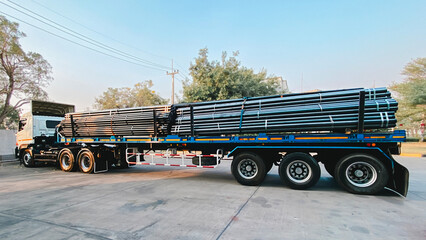 A truck with a long trailer carries rebar for building construction. Construction steel ready to be...