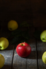Red apple in water drops on wooden background texture