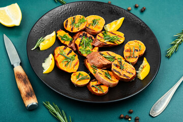 Roasted sweet potatoes on the grill. - 772926402
