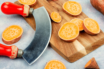 Sliced sweet potato on cutting board. - 772937212
