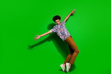 Fototapeta na wymiar Full body size photo of young positive funky guy enjoy dancing standing tiptoes enjoying hip hop isolated on green color background