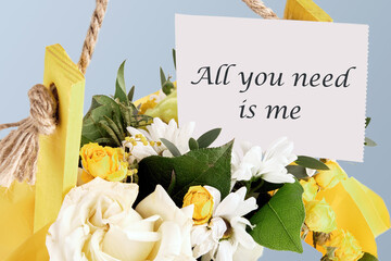 All you need is me. The phrase is written on paper in a basket with flowers. The concept of gifts and celebrations