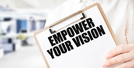 Clipboard with Empower Your Vision text held by a person. Motivational concept and workplace organization.