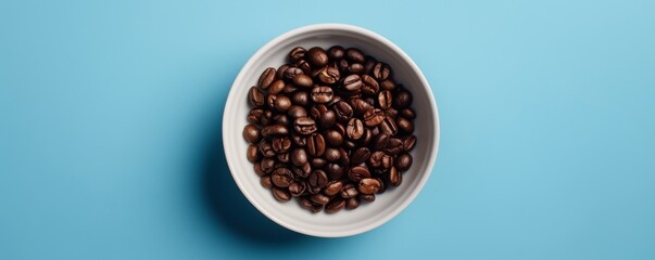 Naklejka premium Top view of coffee beans in a white bowl