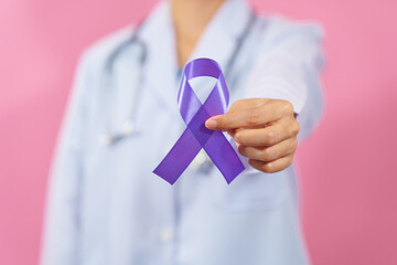 Prostate cancer awareness. Close up medical doctor holding ribbon over pink background isolated....