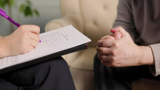 Close up unrecognizable woman psychologist records data in questionnaire