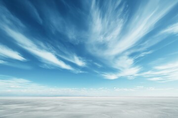Pristine white salt flat under a broad blue sky with dynamic wispy clouds.