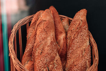 Close up crispy baguettes in a wicker basket, freshly baked bread