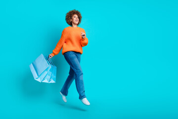 Full length profile photo of attractive person hold shop bags jump run empty space isolated on teal...
