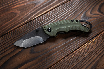 Tactical knife on a wooden background
