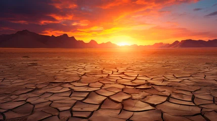 Photo sur Plexiglas Marron profond Dramatic sunset over cracked earth desert landscape