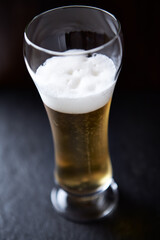 Glass of beer on dark background. Copy space.
