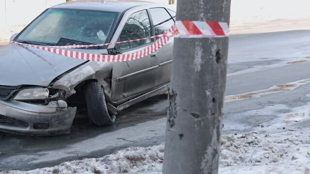 Impacted front, warning tape, vehicle wreckage. With smashed front after accident, car marked off by emergency tape.