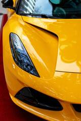 Stunning design of super car parked outdoors painted in vibrant yellow color. Electric headlight...