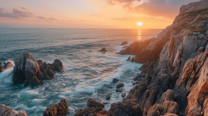 A tranquil scene of ocean cliffs during sunset with the sun's golden rays reflecting off the...