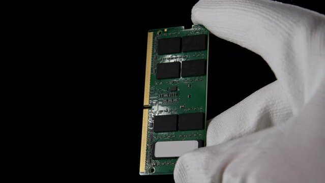 In the Darkness: Hand Securely Grasping RAM DDR4 Sodimm for PC. High quality photo