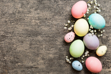 Happy Easter composition. Easter eggs on colored table with gypsophila. Natural dyed colorful eggs background top view with copy space