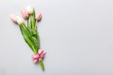 Bouquet of pink tulips on colored table background . Top view with copy space. Waiting for spring....