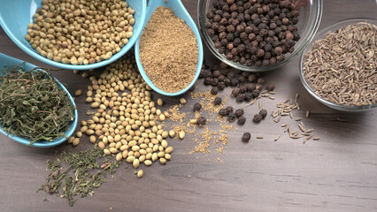 Dried coriander seeds with fresh green leaf isolated on wooden background. Top view. Flat lay