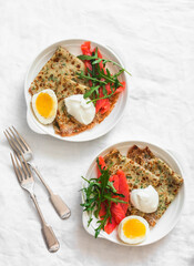 Delicious  breakfast , brunch - potato dill crepes, boiled egg, lightly salted salmon, arugula on a light background, top view