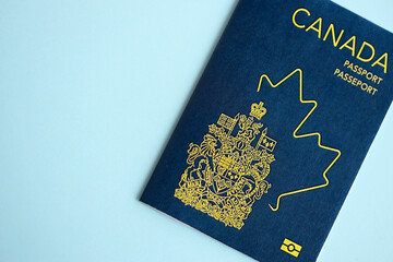 Fototapeta premium Canadian passport on blue background close up. Tourism and citizenship concept