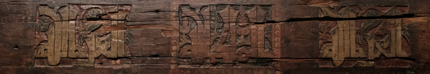 Detail of handcrafted wooden carving showcasing a repeating geometric design, part of traditional artisan furniture decor