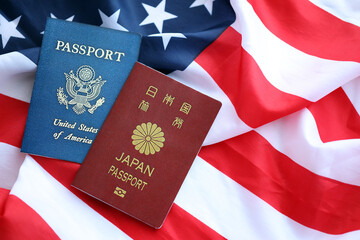 Passport of Japan with US Passport on United States of America folded flag close up