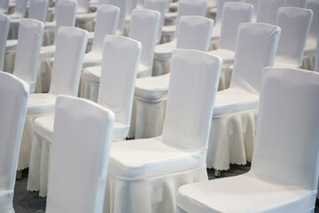 Close-up of white satin chair seats for large business meeting
