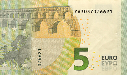 Fragment of one five euro money bill. Colorful details of European union currency banknote of five...