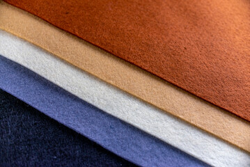 A row of different colored fabrics, including blue, white, and brown. The colors are arranged in a way that creates a sense of depth and texture