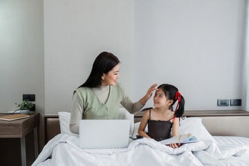 Work from home, freelance and lifestyle concept. Portrait of creative asian female sitting on bed with laptop and her take care of her kid while working