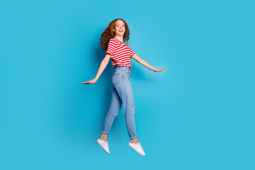 Full length photo of adorable lovely positive woman dressed striped t-shirt jeans flying having fun...