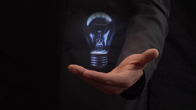 A flashing electric light over the open palm of a businessman. Startup concept and new business idea. Brainstorm.