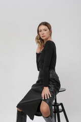 Serie of studio photos of female model in all black look, sh