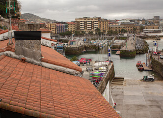 Fototapeta premium a tiled roof. Seabed below. Embankment of the port of San Sebastian, Spain