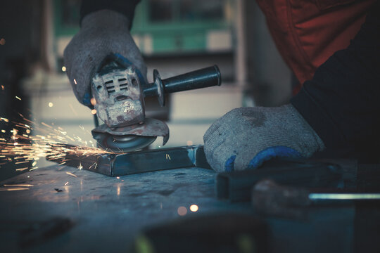 Portraits of a young man welding and grinding steel