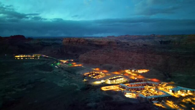 aerial shot of moab utah with red mountains behind the city during sunset
