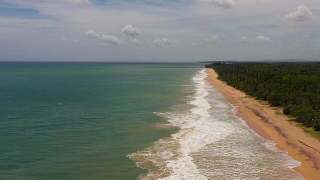 Travel concept: flying over a beautiful sandy beach and a blue ocean. Lankavatara, Sri Lanka.