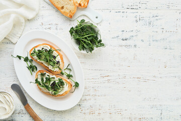 Toast or sandwich with cream cheese and micro greens peas and sunflower. Concept healthy food or snack. Flat lay, copy space.