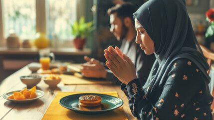 Spiritual Moment of Muslim Couple Engaged in Prayer Before Mealtime - obrazy, fototapety, plakaty