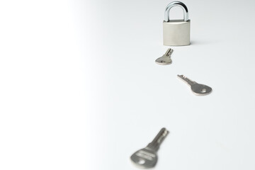 One padlock with many another keys. Many keys and one lock as concept. Different metal keys and one hinged steel padlock on a white background.