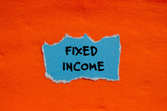 Fixed income words written on blue torn paper piece with orange background. Conceptual business symbol. Copy space.