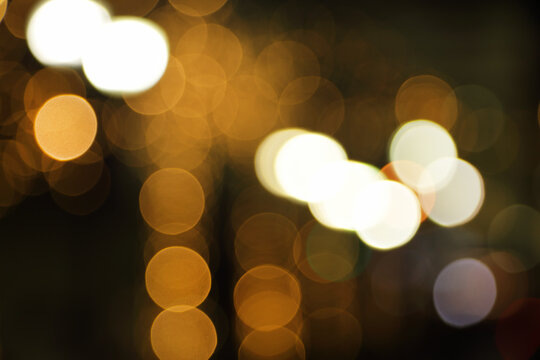 Blurry background image of defocused golden color abstract city street lights at night