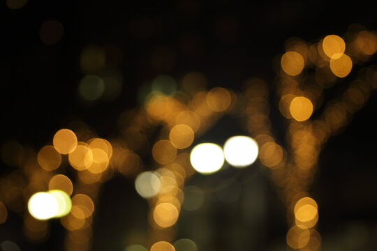 Blurry background image of defocused golden color abstract city street lights at night