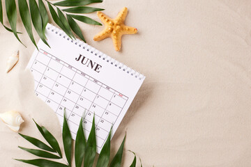 Summer planning time: serene setup with June calendar, starfish, and green foliage, laid out on a...