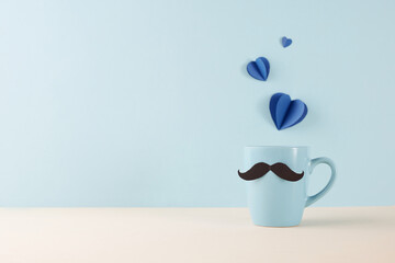 Dad's Special Day: Side view of a whimsical mustache mug with heart-shaped paper cutouts on a pale backdrop, ready for celebration notes