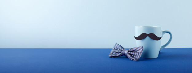 Dapper Dad’s Day: A neat side view of a mustache mug paired with an elegant bowtie, resting on a...