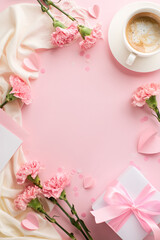 Tribute to Mom's Love: Top view vertical composition of a warm cup of coffee, soft pink carnations, gift box, hearts and white scarf on blush pink background with space for Mother's Day wishes - obrazy, fototapety, plakaty